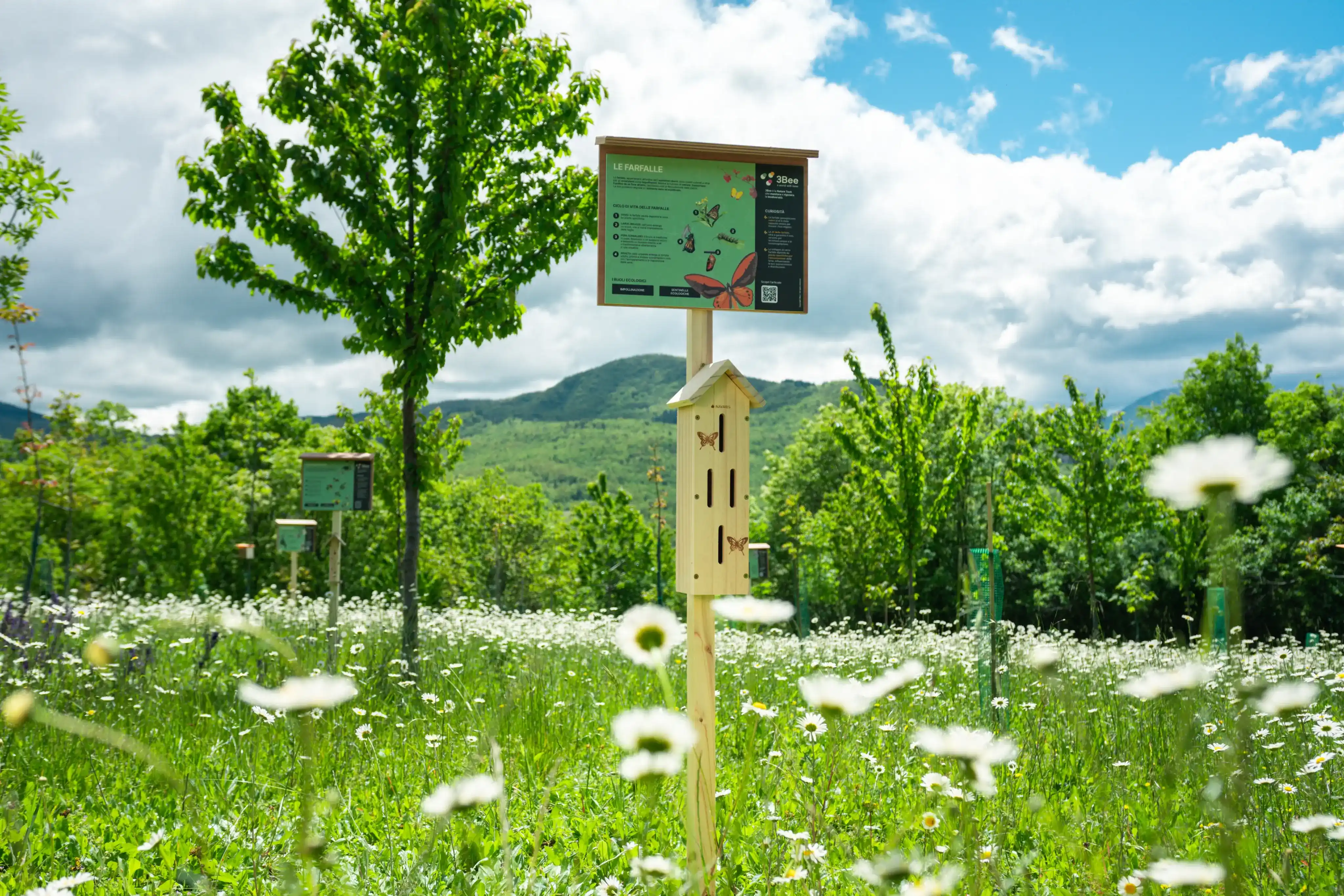 A bug hotel with a sign on top that explains the kind of bugs that can be found inside.